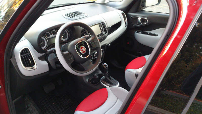Beyond frequent touch points like the “squircle” leather steering wheel and the meaty shifter, the rest of the interior materials are decidedly cheap. Each door panel is a single moulding of hard plastic, with an upholstered armrest of an interesting blob shape for visual contrast. The grey dashboard trim is a soft but scratchy rubber that feels like sandpaper. Again, cheap but unusual. Door handles are also squircle-ish.